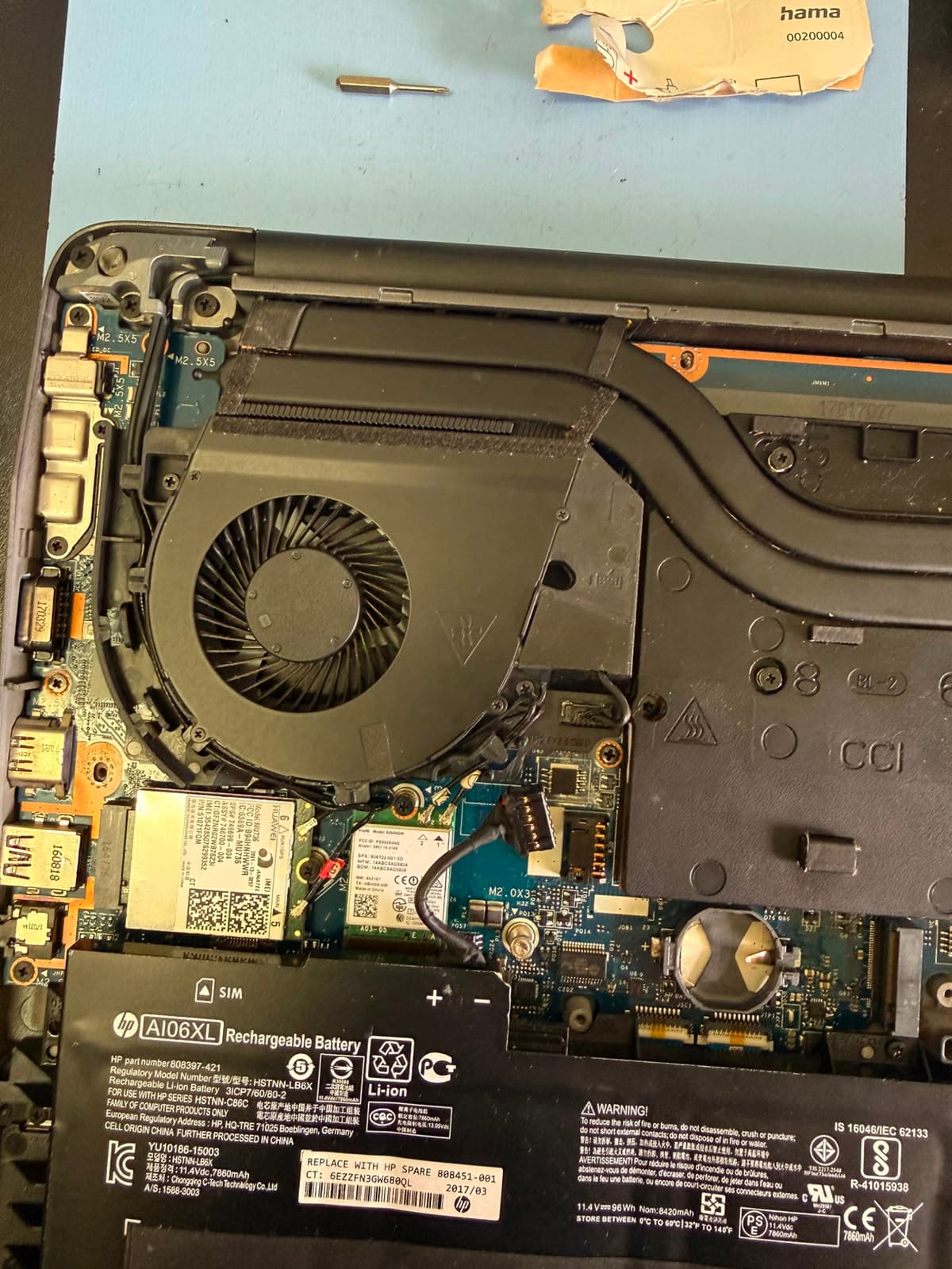 Geöffnetes HP-Notebook mit ausgebauter Bodenplatte: Lüfter, Heatpipe, WLAN-Modul und Akku sind sichtbar.